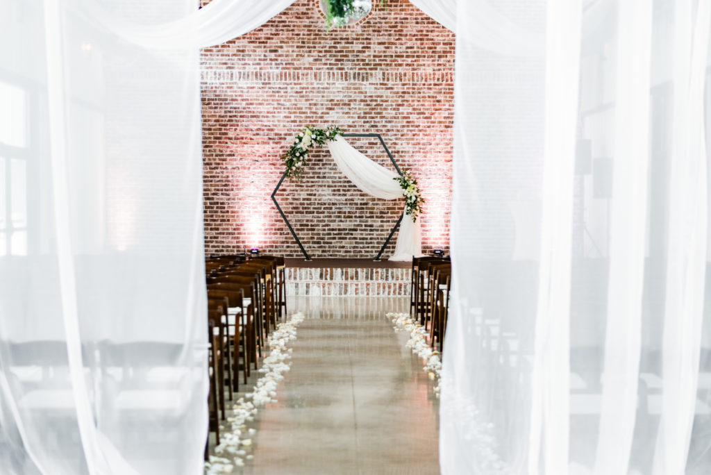 Minimalist indoor ceremony surrounded by large white linen provided by White Azalea Estate
