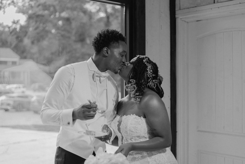 A kiss shared between a bride and groom after cutting cake by Huntsville Alabama photographer, Danielle Jordan